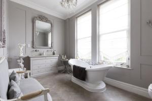 uma casa de banho com uma banheira, um lavatório e um espelho. em High View Large Luxury House em Norwood
