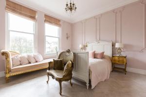 1 dormitorio con cama, banco y ventanas en High View Large Luxury House, en Norwood