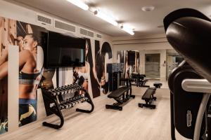 a gym with several tread machines and a tv at be.HOTEL in St. Julianʼs
