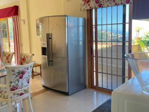 a stainless steel refrigerator in a kitchen with a balcony at Apartamentos Islas Canarias in Icod de los Vinos