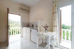 una cucina con tavolo e alcune finestre e bancone di Panorama Apartments updated with infinity pool a Agios Nikolaos
