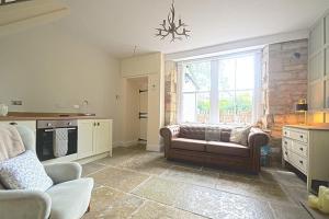 a living room with a couch and a large window at Coquetdale Cottage in Rothbury, Nr National Park in Rothbury