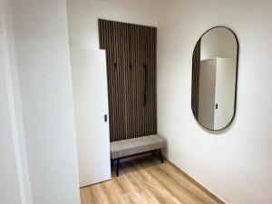 - un dressing avec un miroir et une chaise dans l'établissement Business-Apartment - Citynah, WLAN, Drucker, Netflix & Parken, à Chemnitz