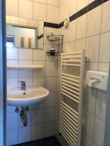 bagno bianco con lavandino e specchio di Appartment Isabelle - Kamille a Presseggersee