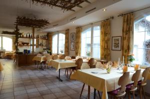 a restaurant with tables and chairs and windows at Hotel Arkanum in Salgesch