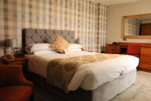 a bedroom with a large bed and a desk at The Oakwheel in Scarborough