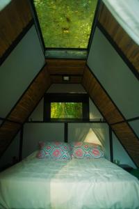 Bett in einem kleinen Zimmer mit Dach in der Unterkunft 8 Caminos Glamping in Carmen de Apicalá