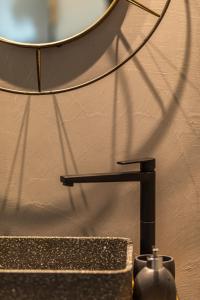 a mirror sitting on a wall next to a sink at Mani Theasis in Stoupa