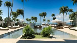 - une piscine avec des chaises longues et des palmiers dans l'établissement 2BR Apartment at Aquarella AG02, à Juan Dolio