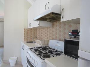 cocina blanca con fogones en Bavaro Hostel, en Punta Cana