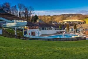 - une grande piscine avec toboggan dans la cour dans l'établissement Charming Copse Corner Cabin in Devon's Countryside, à Chudleigh