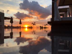a reflection of a sunset in a body of water at Panorama Apartments updated with infinity pool in Agios Nikolaos