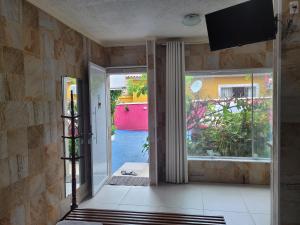 a room with a door open to a courtyard at Pousada Mar & Sol de Camburi in Camburi