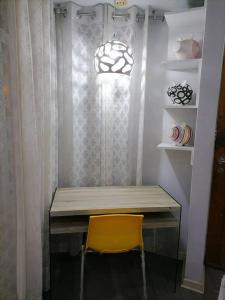 a wooden table with a yellow chair in a room at Mini independent apartment in Lima