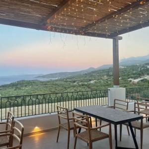 a table and chairs on a balcony with a view at Panorama Apartments updated with infinity pool in Agios Nikolaos