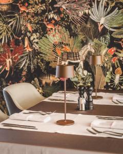 una mesa con dos lámparas y una pared floral en SIGNUM Hotel en Podgorica