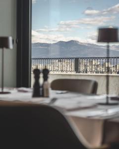 a table with a view of the mountains through a window at SIGNUM Hotel in Podgorica