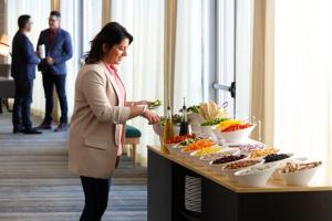 a woman standing in front of a buffet of food at Holiday Inn Hotel & Suites Springfield, an IHG Hotel in Springfield