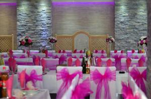 a room with pink chairs and tables with pink bows at Bački dvor 