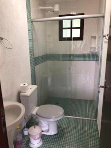 a bathroom with a toilet and a sink at Chácara condomínio perto de SP in Ibiúna