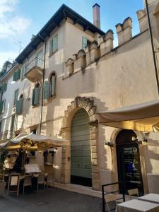a building with a door and some tables and umbrellas at Casa Turandot Verona in Verona