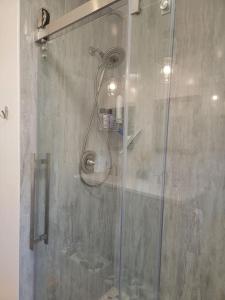 een douche met een glazen deur in de badkamer bij 3 Bedroom Bay Home with Private Dock & all the Amenities in Onemo