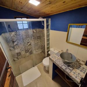 ein Bad mit einer Dusche, einem Waschbecken und einem WC in der Unterkunft Casa aconchegante no coração do Bairro do Quilombo in São Bento do Sapucaí