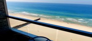uma vista para a praia a partir de uma janela com o oceano em Apart Hotel TLV/Bat Yam Beach Front 1207 em Bat Yam