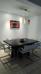 una mesa de comedor negra y sillas en una habitación en CASA CON PILETA EN VILLA ATILIA, LUJAN DE CUYO en Luján de Cuyo