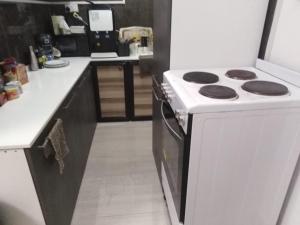 a kitchen with a white stove and a counter at Cheerful 1BR Close to Abu Dhabi Airport and YAS Island in Abu Dhabi