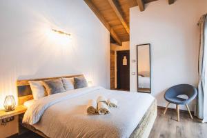 Coste del Gaggio - Country House B&B - Garda Trentino في Drena: غرفة نوم بسرير مع حذاء ومرآة