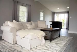 uma sala de estar com um sofá branco e uma mesa em Palm Bay Coastal Chef House 3B 2Bth 10min to Beach em Palm Bay