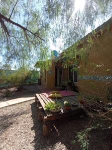 a wooden picnic table in front of a house at Montaña mendocina in Ciudad Lujan de Cuyo