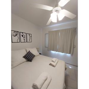 1 dormitorio con cama blanca y ventilador de techo en Hermoso depto. en Godoy Cruz, Mendoza! en Godoy Cruz
