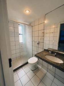 y baño con aseo, lavabo y ducha. en Apartamento a 200 metros da feirinha da beira mar, en Fortaleza