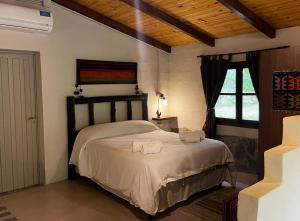 a bedroom with a bed with two towels on it at Cabaña tierra verde in Yala