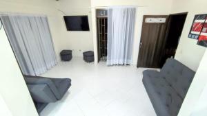 - un salon avec deux chaises et une télévision dans l'établissement Apartamento con vista al embalse, à Guatapé