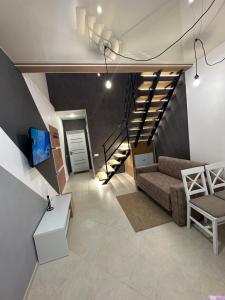 sala de estar con sofá y escalera en Апартаменты Well - Being en Umanʼ