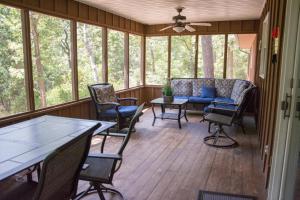a screened in porch with chairs and a couch at The Bavarian Village Resort in Branson