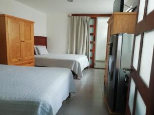 a hotel room with two beds and a refrigerator at Casa Caracol Guanajuato in Guanajuato