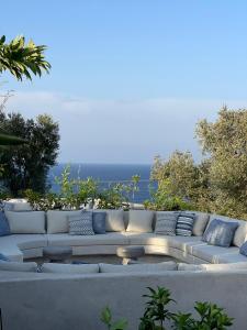 a white couch with pillows sitting on a patio at Panorama Apartments updated with infinity pool in Agios Nikolaos