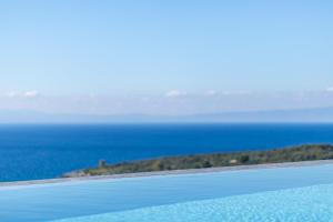 a view of the ocean from the edge of a swimming pool at Mani Theasis in Stoupa