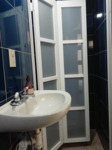 baño con lavabo y puerta de cristal en Casa Caracol Guanajuato en Guanajuato