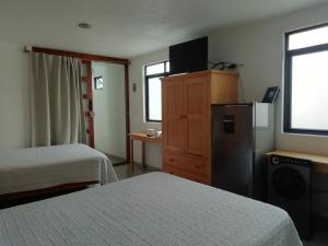 a hotel room with two beds and a refrigerator at Casa Caracol Guanajuato in Guanajuato