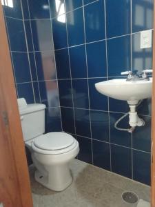 a blue tiled bathroom with a toilet and a sink at Casa Caracol Guanajuato in Guanajuato