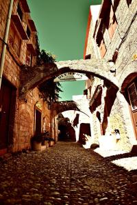 an old stone building with an archway in a street at Olympos Pension in Rhodes Town