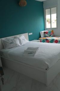 1 cama blanca en un dormitorio con una pared azul en appartement de luxe front mer à DAR BOUAAZA en Dar Bouazza