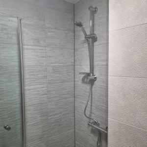 a shower with a shower head in a bathroom at Prescot Rooms in Liverpool