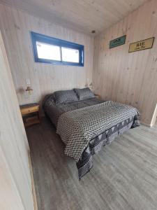 1 dormitorio con 1 cama en una habitación de madera en Cabaña para 2 con jacuzzi campo mar, en Matanzas