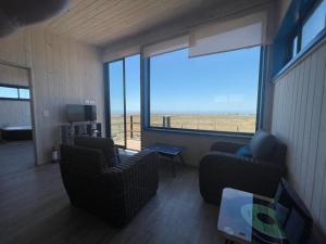 sala de estar con 2 sillas y ventana grande en Cabaña para 2 con jacuzzi campo mar, en Matanzas